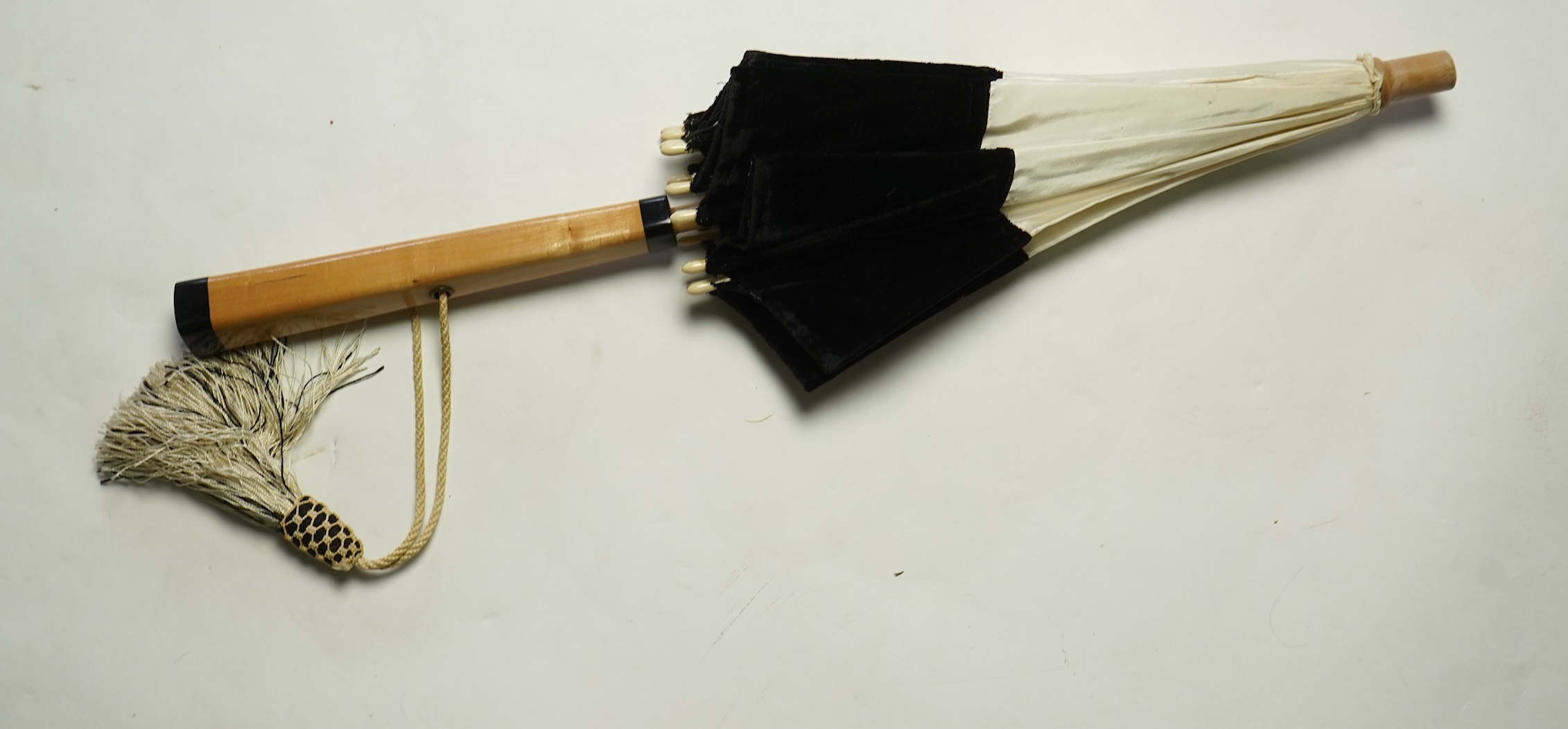 An unusual early 20th century cream silk and black velvet parasol and silk corded tassel. 64cm high. Condition - good